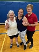 3 ladies with smiles celebrate at the end of the Red, White, & You workout.