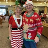 Man and woman smiling in Christmas sweaters