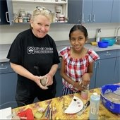 Picture of pottery class participant and instructor