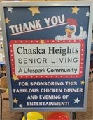 Picture of a sign recognizing sponsor, Chaska Heights Senior Living, for The Lodge Chicken Dinner.
