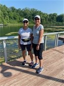 Two ladies walking at Chaska's Firemens Park on the boardwalk by the clayhole. 