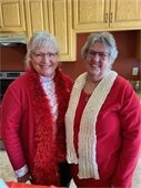 Image of two smiling ladies wearing red to celebrate at Lodge Valentine's Party.  