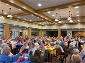 Picture of Large Audience waving their hands to the music during the Lodge Chicken Dinner.