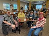 Group of four sit a table and enjoy the games at the Halloween Hoedown at The Lodge.
