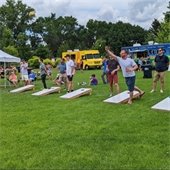 people playing bean bags at an outdoor festival in Chaska